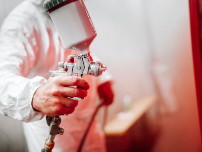 close up details of industrial worker, mechanic engineer painter painting a car
