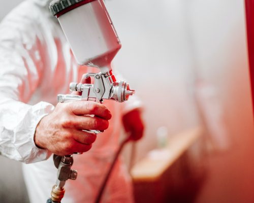 close up details of industrial worker, mechanic engineer painter painting a car
